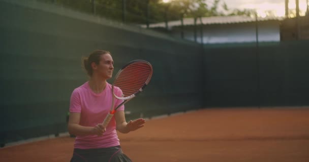 Slow Motion tenis kortu ağındaki tenis antrenmanının ticari görüntüleri. Tenis oynayan bir bayan sporcunun düz görüntüsü. Genç bir sporcu spor eğitiminde topa vuruyor. — Stok video