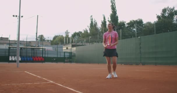 Atletická mladá žena tenistka. Portrét pohledné ženy s tenisovou raketou v tenisové uniformě chůze venku. — Stock video