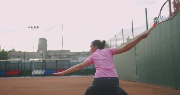 Jogadora de tênis em ação durante o jogo no estádio profissional. Ela está usando roupas esportivas sem marca. O estádio — Vídeo de Stock