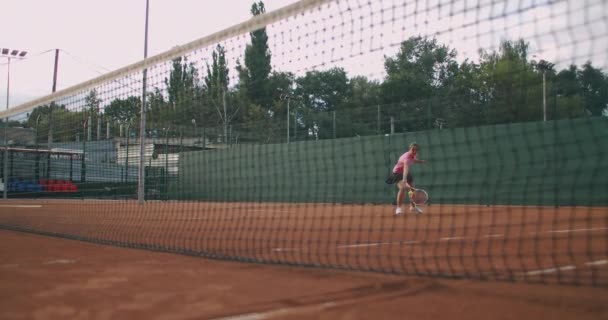 Bruneta dívka hraje tenis s raketou, míčky a sportovní vybavení. — Stock video