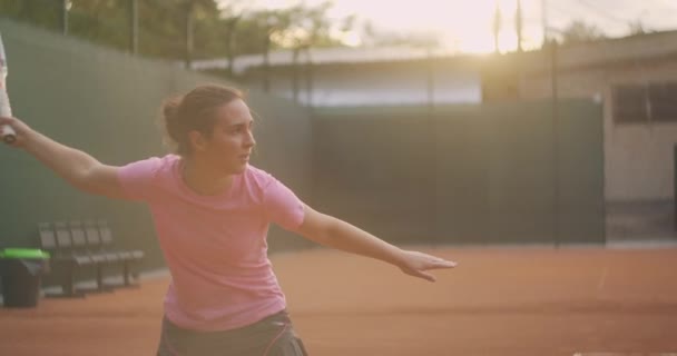 Profesyonel donanımlı kadın tenis raketiyle tenis topuna sert vuruyor. Kadın tenisçi oyun sırasında iş başında. Üzerinde markasız spor giysiler var.. — Stok video