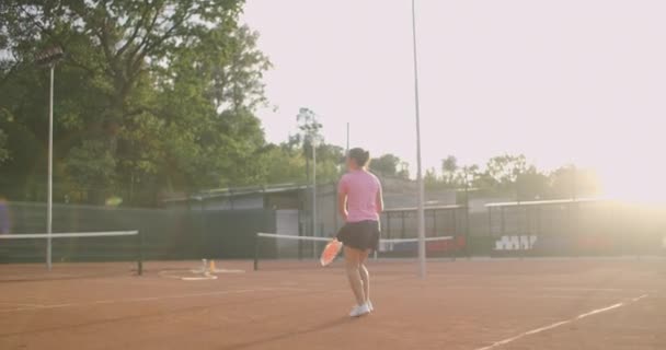 年轻的白人女子在球场上打网球，慢动作地回球 — 图库视频影像