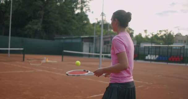 Втомлений брюнетка-жінка тенісистка прогулюється по тенісному корту, відновлюючись і концентруючись. Перерва в тенісному матчі. Тенісний гравець після матчу на карті на заході сонця в повільному русі . — стокове відео