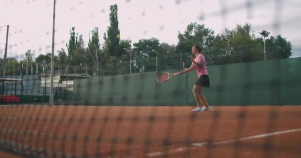 Slow motion kvinnlig tennisspelare slår bollen under ett spel — Stockvideo