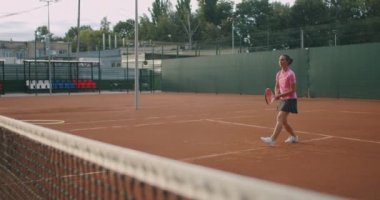 Spor giyim sektöründe tenis oynayan genç kadın ve erkek. Kadın tenisçinin orta boy fotoğrafı..