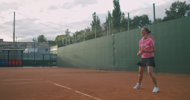 Női teniszező akcióban játék közben a profi stadionban. Márkátlan sportruhát visel. A stadionban. — Stock videók