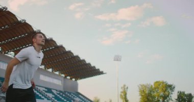 Ağır çekimde, profesyonel futbolcu stadyumda topa koşuyor. Futbol Futbolcusu Başlık Yapıyor. Futbol Futbolcusu Başlık Yapıyor. 