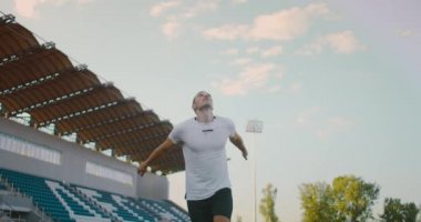 Ağır çekimde, profesyonel futbolcu stadyumda topa koşuyor. Futbol Futbolcusu Başlık Yapıyor. Futbol Futbolcusu Başlık Yapıyor. 