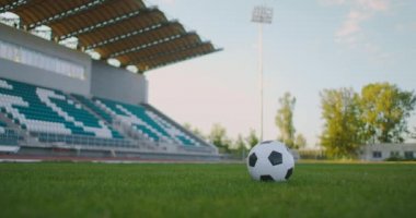Atletik kramponlarda bir futbol topunu tekmelerken yavaş çekimde kapat.