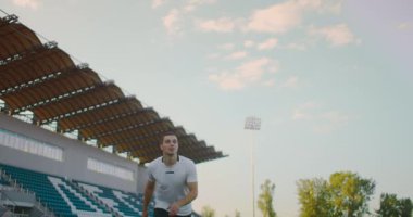 Ağır çekimde, profesyonel futbolcu stadyumda topa koşuyor. Futbol Futbolcusu Başlık Yapıyor. Futbol Futbolcusu Başlık Yapıyor. 