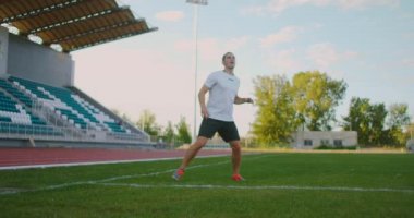 Üniformalı profesyonel bir futbolcu takım arkadaşından pas alır, futbol yeteneğini gösteren göğsüyle topu tutar ve rakiplerinden topla kaçar.
