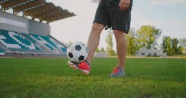 Erkek bir futbolcu yavaş çekimde futbol topunu tekmeliyor. Topu doldurmak için.. 