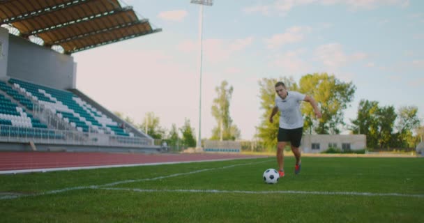 Focista végez kiemelkedő játék közben egy futball játék egy profi szabadtéri futball stadionban. A játékos márkátlan egyenruhát visel. Stadion és tömeg — Stock videók