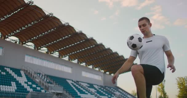 Profesjonalny piłkarz żongluje piłką. socker gracz w białym mundurze piłkarskim na stadionie — Wideo stockowe