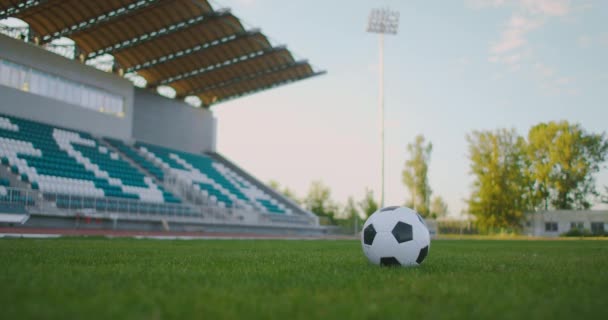 Закрыть в замедленной съемке, пиная футбольный мяч в атлетических бутсах — стоковое видео