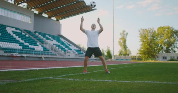 Profesjonalny piłkarz w mundurze otrzymuje przepustkę od kolegi z drużyny, radzi sobie z piłką piersiową pokazując umiejętności piłki nożnej i ucieka przed przeciwnikami z piłką — Wideo stockowe