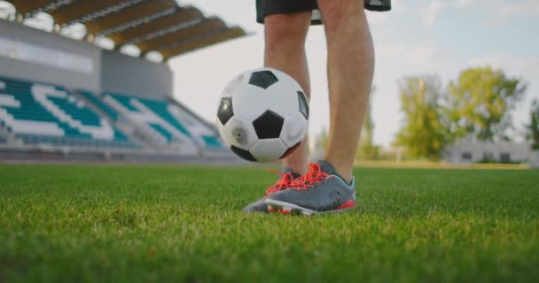 Ein Mann auf einem Fußballplatz hüpft in Zeitlupe in Sportgeräten einen Fußball — Stockvideo