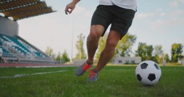 Profesyonel futbolcu bir adam bir stadyumdaki futbol sahasında futbol topuyla koşar ve mükemmel top sürüşünü ve top kontrolünü gösterir..