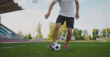 Stadyumda bir futbolcu koşarken futbol topuyla top sürme gösterisi yapıyor. Mükemmel bir futbolcu ve top kontrolü yeteneği.