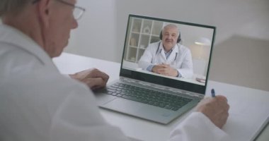 Pratisyen, tıp profesörünün online konferansını dinliyor, not defteri ekranını izliyor ve notlar alıyor.