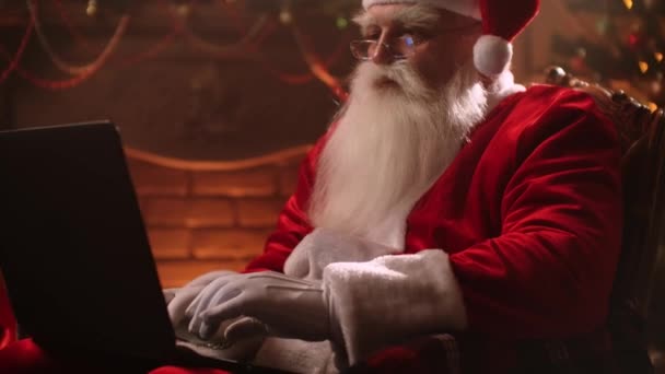 Atmosfera quente Papai Noel na sala de estar usando laptop. — Vídeo de Stock