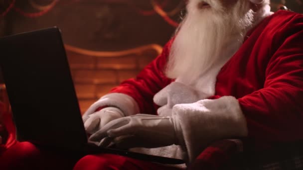 Atmosfera quente Papai Noel na sala de estar usando laptop. — Vídeo de Stock