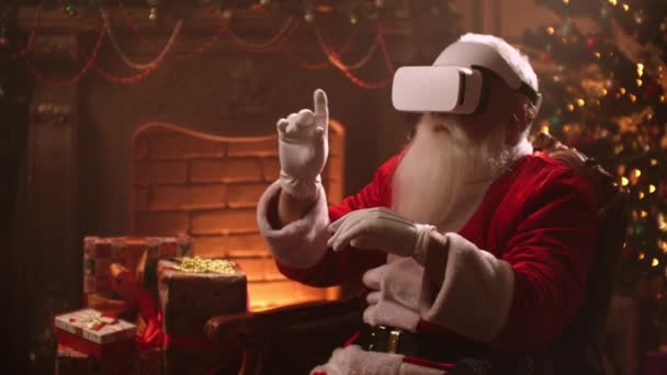 Santa claus sätter på sig Vr hjälm och surfa virtuell verklighet, isolerad på jul anda, teknik koncept närbild 4k bilder. — Stockvideo