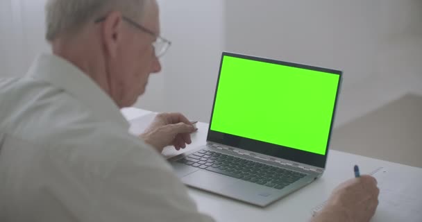 Personne âgée apprend en ligne, à l'aide d'un ordinateur portable, écran vert pour chroma technologie clé, enseignement à distance — Video