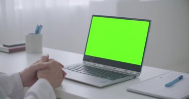Krom ekranlı dizüstü bilgisayar klinikteki doktorun masasında, video kaset konsepti
