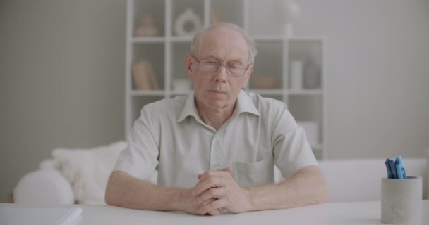 Retrato de homem idoso olhando para a câmera e cabeça acenando, ouvindo pessoa durante a conversa por vídeo, tiro médio — Vídeo de Stock