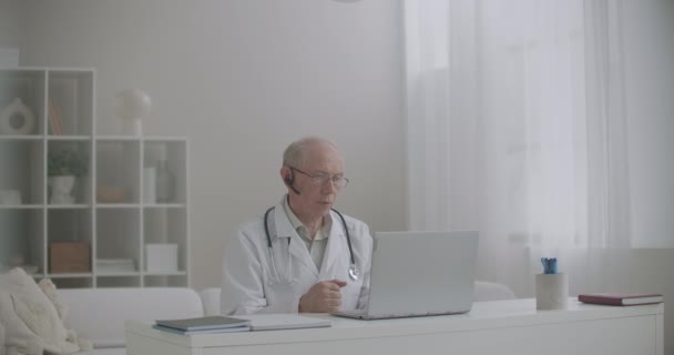 Mužský zkušený virolog přednáší online pomocí notebooku s webovou kamerou a internetem, vzdálená konference — Stock video