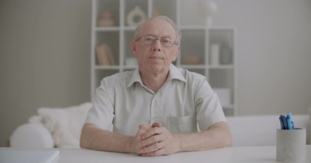 Retiree man is greeting and talking distantly by online chat, medium portrait at living room, communicating by internet — Vídeo de Stock