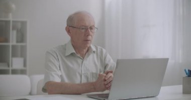 Yaşlı adam internetten internetteki bilgisayarla, internetteki bilgisayarla, evde kalıp videoyla arıyor.