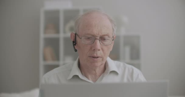 Portrait of retiree man is chatting online by video call on laptop, stay home at pandemic of coronavirus — Stock Video