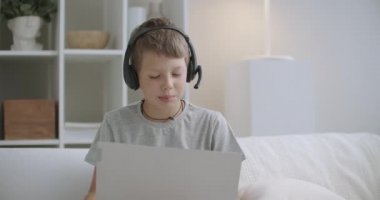 Evdeki liseli çocuğun portresi, internetten internet bağlantısı ile sohbet etmek, evdeki oturma odasında oturmak.