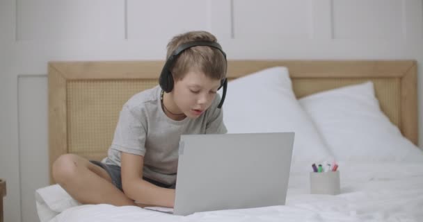 Malý chlapec kreslí a komunikuje on-line notebookem s wifi doma, zábava moderních dětí — Stock video