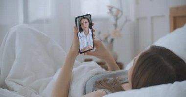 Aile terapistiyle konuşmak için internetten sohbet eden bir kadın ve koronavirüs salgını sırasındaki olası belirtileri kontrol ediyor. Doktorla video konferansı aracılığıyla akıllı telefon danışmanlığında tıbbi uygulama kullanan bir kadın.