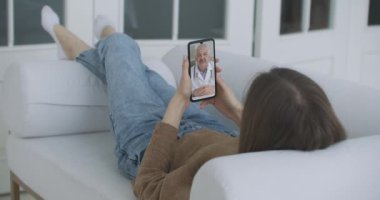 Doktoruyla video konferans uygulaması üzerinden konuşmak için akıllı telefonu kullanan bir kadın. Semptomları Denetleyen, Doktorla Konuşan, Çevrimiçi Video Sohbet Uygulaması Kullanan Kişi
