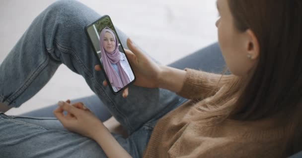 Femme utilisant l'application médicale sur smartphone consultation avec un médecin par vidéoconférence. Femme utilisant le chat en ligne pour parler avec un thérapeute familial et vérifie les symptômes possibles pendant la pandémie de coronavirus. — Video