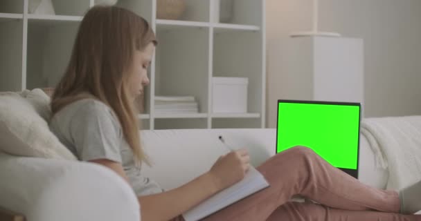 Adolescent fille apprend en ligne de la maison, visualisation leçon en ligne sur ordinateur portable avec écran vert pour chroma technologie clé — Video