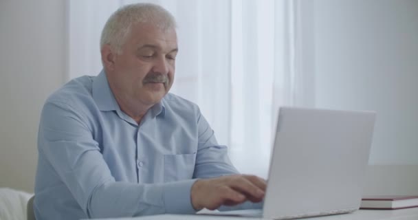 Ache in neck of office worker during typing on notebook in working place, man is rubbing skin, massaging for relaxing muscles — Stock Video