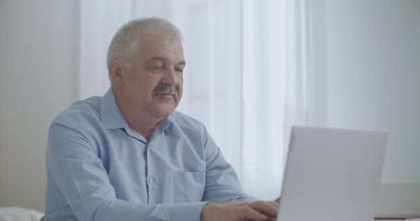 Homem com dor de dente está trabalhando no escritório com laptop, esfregando bochecha para aliviar a dor dos dentes, problemas com a saúde no dia de trabalho — Vídeo de Stock