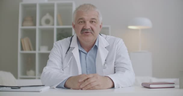 Médico se está comunicando con el paciente o colega por videollamada, vista de retrato desde la cámara web de la computadora portátil — Vídeos de Stock