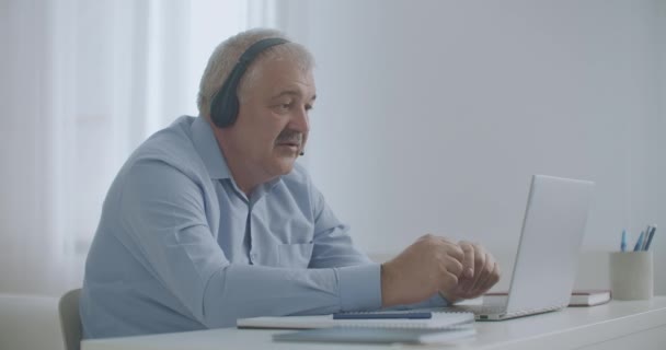 Middle-aged man is talking by video chat with colleagues, working remotely, connecting with departments — Stock Video