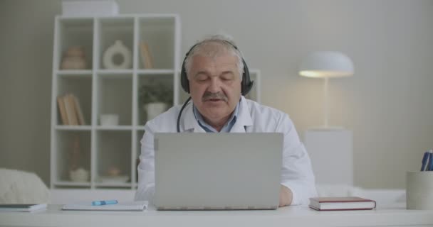 Telegeneeskunde sessie met de beste buitenlandse arts kinderarts, mannelijke arts is online te raadplegen, werken vanuit zijn kantoor in kliniek — Stockvideo