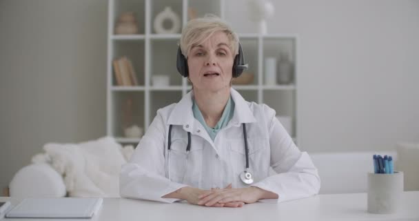 Médecin-chef femme parle avec les employés en ligne par vidéochat, portrait de dame âgée au bureau de l'hôpital — Video