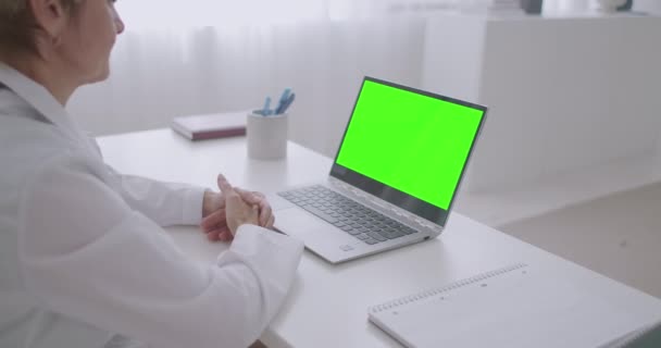 Online találkozó orvossal, nő orvos nézi zöld kijelző laptop chroma kulcs technológia, kommunikáció online video chat — Stock videók