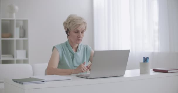 Mujer está llevando a cabo la formación en línea por Internet, hablando por videocall en el portátil, trabajando desde casa, e-learning — Vídeo de stock