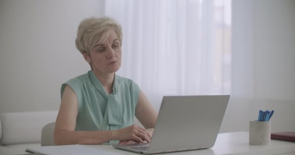 婦人科医はウェブセミナーやノートパソコンの前に座ってウェブカメラを見たり話したり講義したりしています — ストック動画