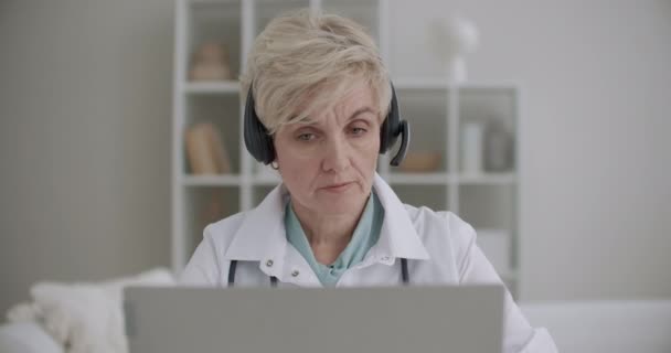 Online ραντεβού με έμπειρη γυναίκα γιατρό, ηλικιωμένη γυναίκα επικοινωνεί online με ασθενή ή συνάδελφο — Αρχείο Βίντεο